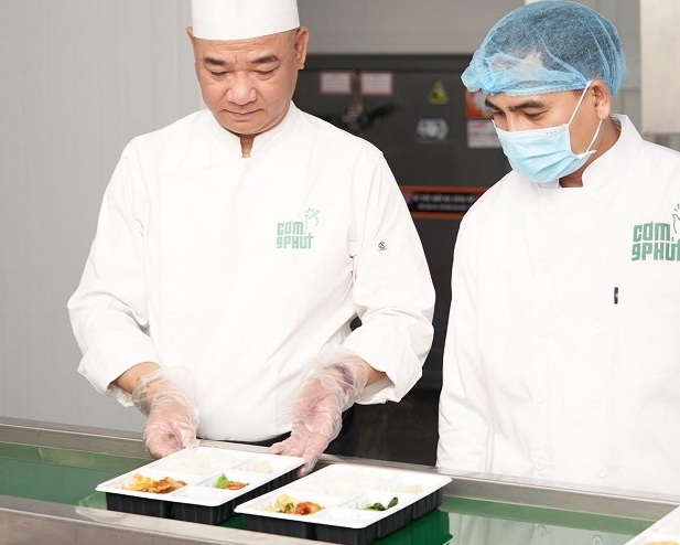 CEO Đỗ Minh Phương (phải) cùng đầu bếp Phạm Tuấn Hải chuẩn hóa sản phẩm của Cơm 9 phút.