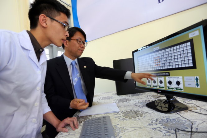 Chuyên gia hạt nhân Hàn Quốc hướng dẫn sinh viên nhập liệu cho hệ thống mô phỏng. Ảnh: tuoitre.vn