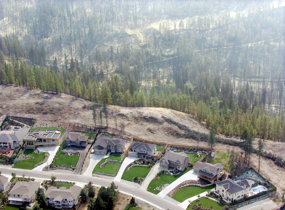 Một dãy nhà nhìn từ trên cao tại Kelowna, tỉnh British Columbia vào Chủ nhật, 24/8/2003. Cháy rừng tại Công viên núi Okanagan đã tràn qua khu phố này. Nguồn: Chuck Stoody