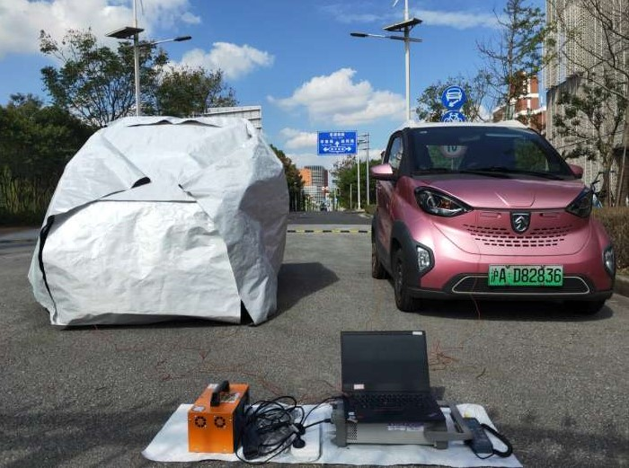 Một chiếc xe điện được phủ bằng tấm phủ nhiệt vào ban ngày bên cạnh một chiếc xe để không. Ảnh: Huaxu Qiao