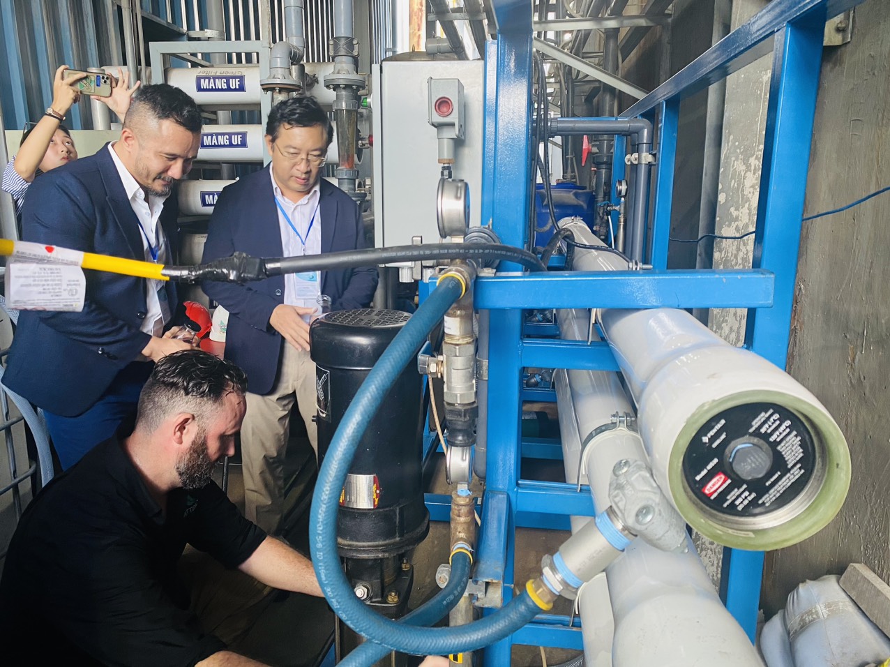 Ông Phạm Hồng Quất, Cục trưởng Cục Phát triển thị trường và doanh nghiệp KH&CN kiểm tra thực tế công nghệ xử lý nước nano được lắp đặt thử nghiệm. Ảnh: VGP