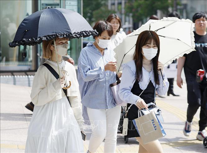 Người dân che dù tránh nắng nóng tại Fukuoka, Nhật Bản - Ảnh: Kyodo/TTXVN