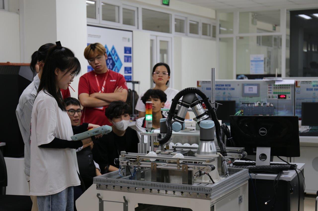 Trong Lab Tour, học sinh cấp 3 được giới thiệu về cánh tay robot lắp ráp bóng đèn trong một dây chuyền sản xuất hoàn toàn tự động tại “Trung tâm kỹ thuật nhà máy số thông minh” (Tầng 11-Nhà D8, Đại học Bách khoa Hà Nội).