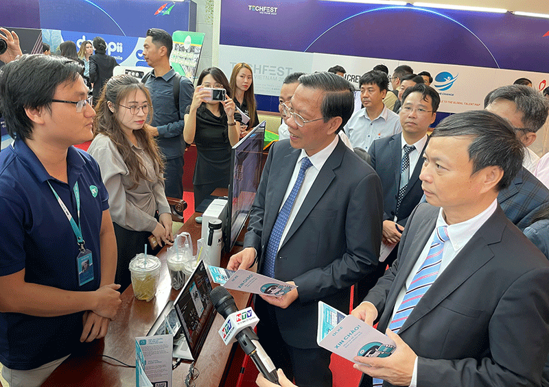 Thứ trưởng Bộ KH&CN Hoàng Minh (ngoài cùng bên phải) và Chủ tịch UBND TPHCM Phan Văn Mãi (giữa) tham quan các gian hàng khởi nghiệp.  Ảnh: KA