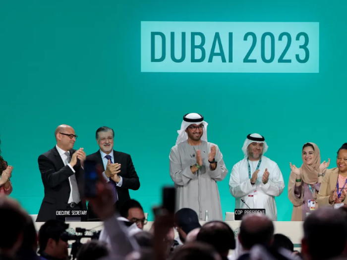 Chủ tịch Hội nghị COP28, Ahmed Al Jaber, và những người khác tán thưởng việc các quốc gia đạt được thỏa thuận khí hậu đầu tiên về việc chuyển đổi khỏi nhiên liệu hóa thạch. Ảnh: GIUSEPPE CACACE