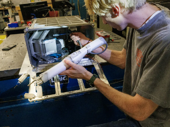 Kĩ sư của Đại học Nebraska, Mỹ đang đặt cánh tay robot vào hộp đựng. Một bác sĩ phẫu thuật trên Trái Đất sẽ hướng dẫn robot từ xa để thực hiện một cuộc phẫu thuật mô phỏng trên Trạm vũ trụ quốc tế. Ảnh: Craig Chandler