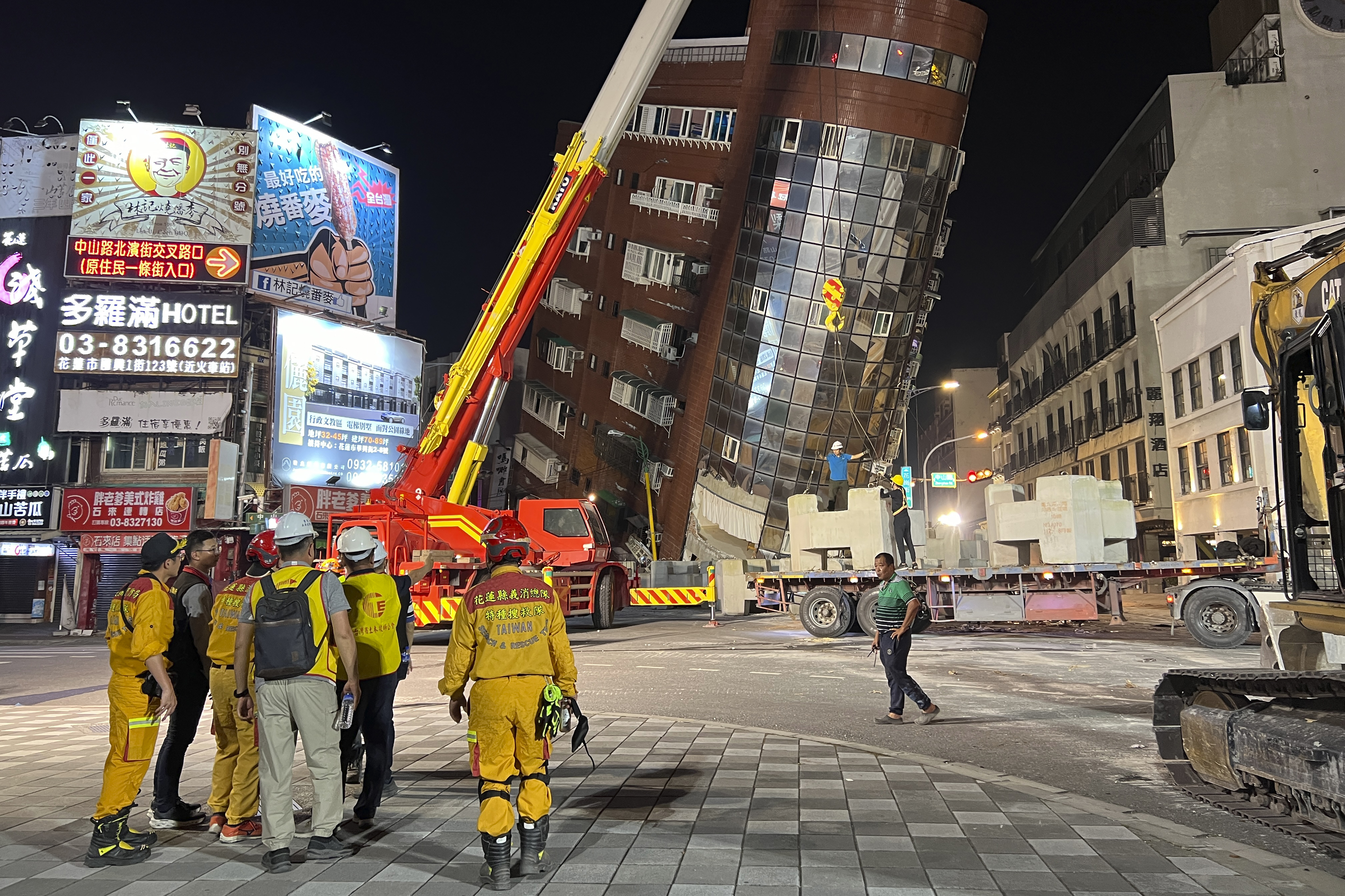 Nhân viên cứu hộ đứng gần một tòa nhà nghiên sau trận động đất ở Hoa Liên, Đài Loan vào ngày 3/4. Ảnh: Lai/AP