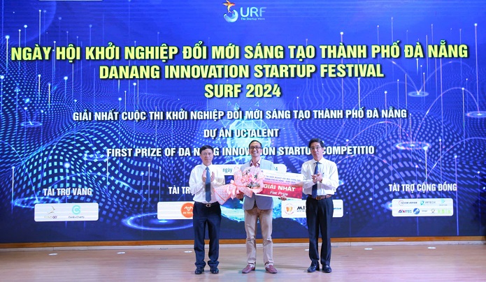 Thứ trưởng Bộ Khoa học và Công nghệ Hoàng Minh (bên trái) và Phó Chủ tịch UBND thành phố Trần Chí Cường (bên phải) trao giải Nhất cho dự án UC Talent. Ảnh: Báo Đà Nẵng