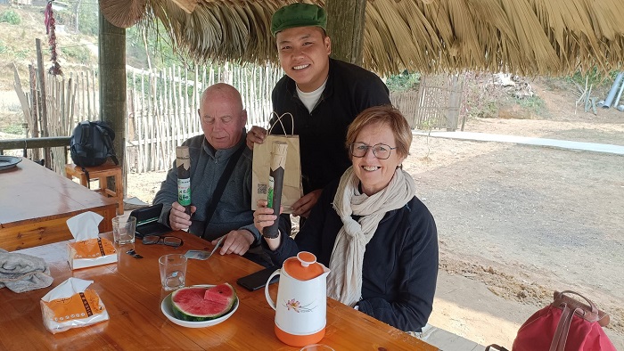 Vàng A Bình ở Bản Liền Homestay (giữa) đưa trà trong ống tre tới du khách nước ngoài.