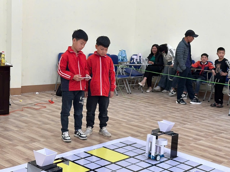 Hai thí sinh trong cuộc thi lập trình và điều khiển KCbot dành cho học sinh tiểu học toàn huyện Văn Quan ngày 4/4/2025. Ảnh: Văn Quan