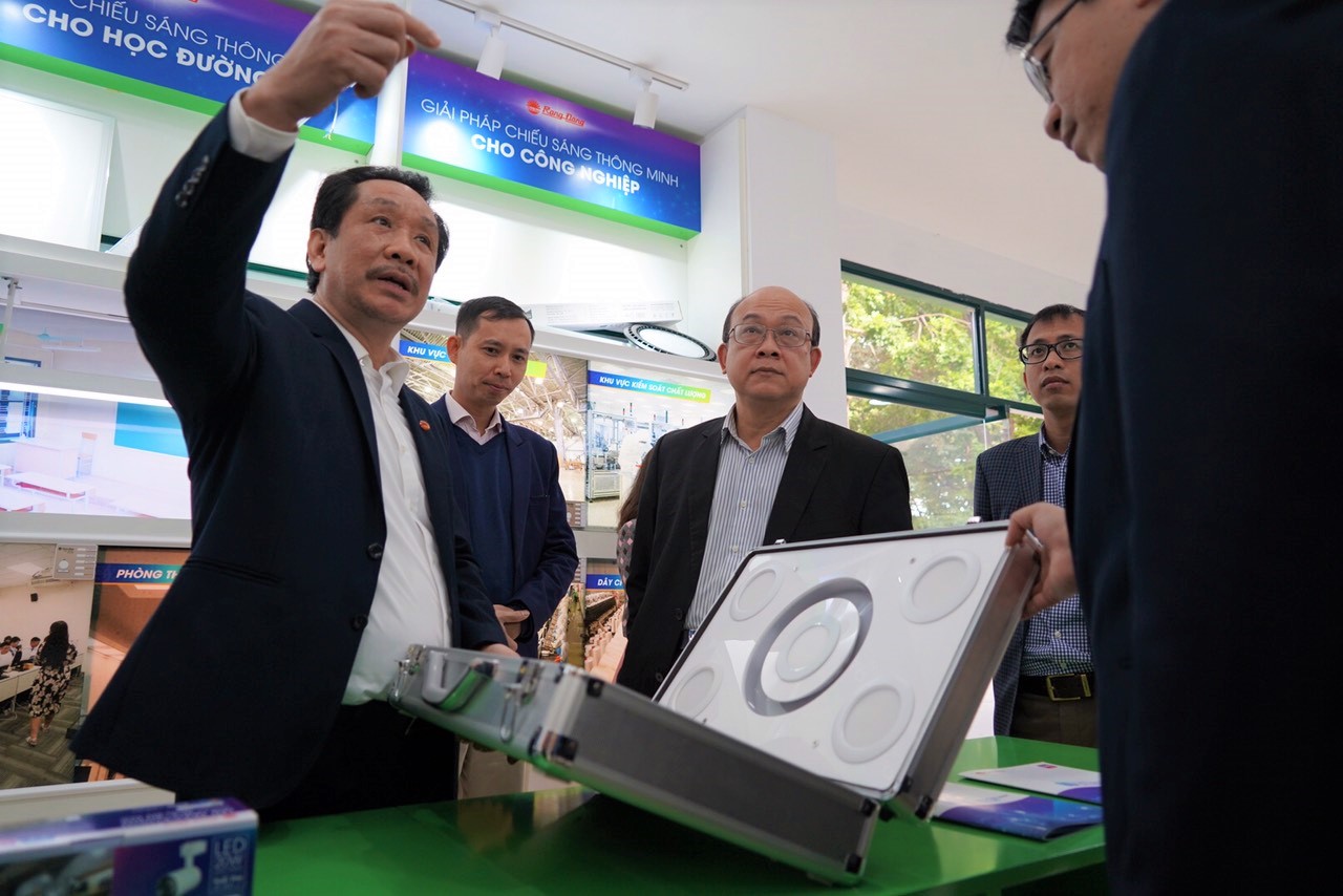Hiệu trưởng ĐH Bách khoa HN Huỳnh Quyết Thắng (giữa) nghe ông Nguyễn Đoàn Kết (trái), Phó tổng Giám đốc Công ty CP Bóng đèn Phích nước Rạng Đông, giới thiệu về công nghệ chiếu sáng thông minh. Ảnh: CCPR-Hạnh Phạm